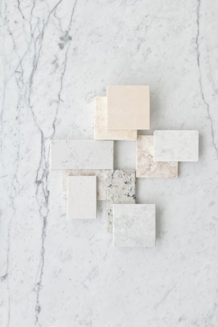 Aesthetic flat lay of various marble tiles arranged on a textured marble surface.